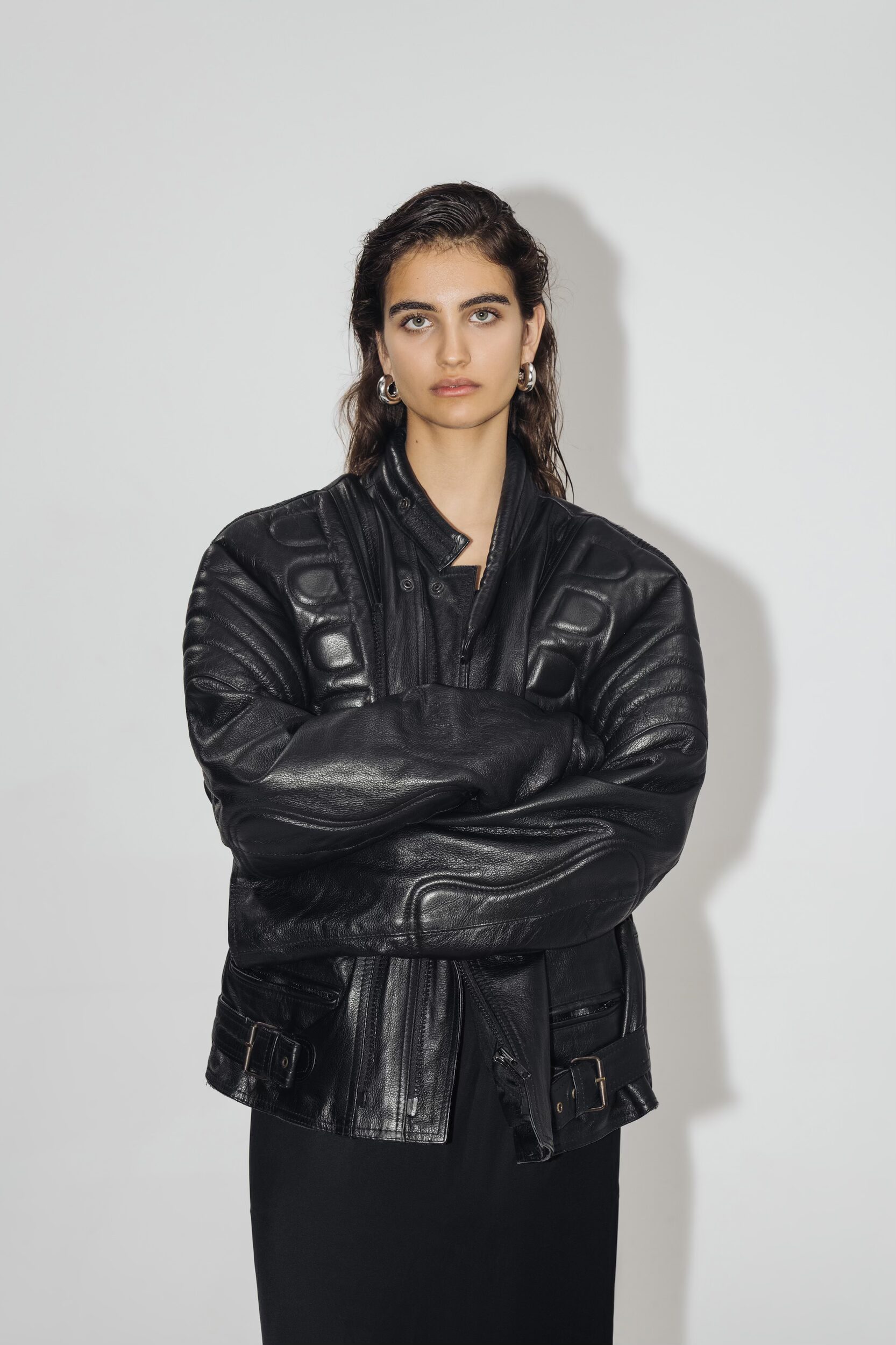 Image of a person standing against a white background with a leather jacket on